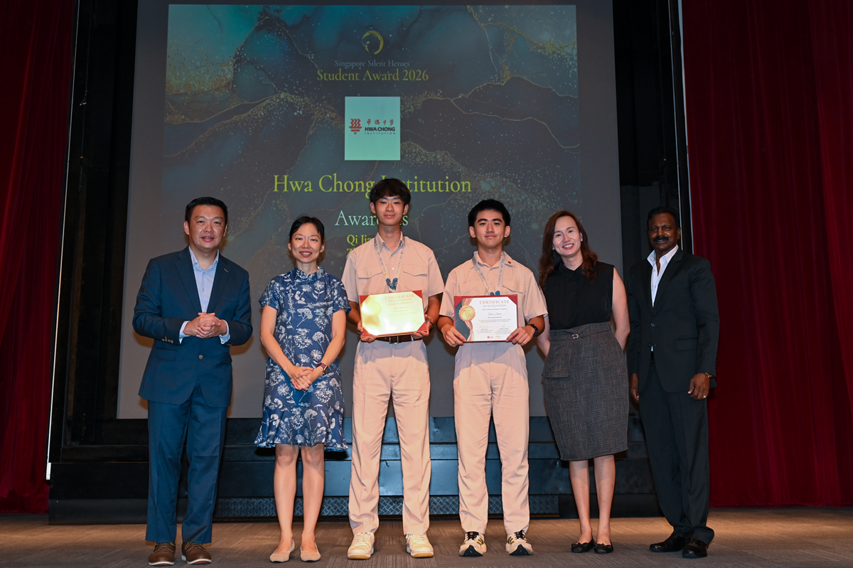 HCI students Qi Jiachuan and Zhou Junbo receive the Singapore Silent Heroes (Student) Award 2026 alongside Minister of State Ms Jasmin Lau and distinguished guests. descriptive alt text.